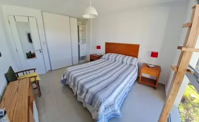 a bedroom with a bed with a striped blanket on it at Medilan Kempes Exclusivo in Cordoba