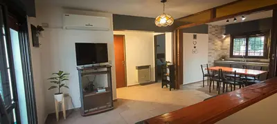a living room with a television and a dining room at Departamento HOSPITAL PRIVADO - QUALITY - 