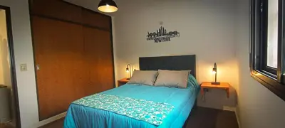 a bedroom with a bed with a blue comforter at Departamento HOSPITAL PRIVADO - QUALITY - 