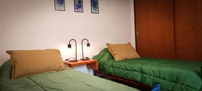 a room with two beds and a table with lamps at Departamento HOSPITAL PRIVADO - QUALITY - 