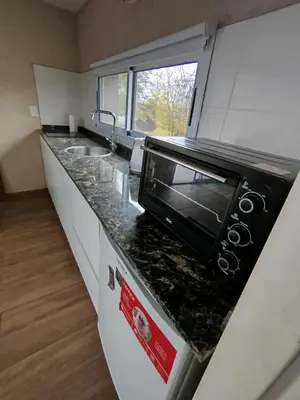 a kitchen with a sink and a microwave on a counter at DelViento Cabañas in Las Rabonas