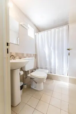 a white bathroom with a sink and a toilet at Depto con excelente ubicación by Lofty in Cordoba