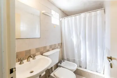 a bathroom with a toilet and a sink and a mirror at Depto con excelente ubicación by Lofty in Cordoba