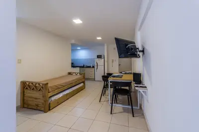 a room with a bed and a kitchen with a table at Depto con excelente ubicación by Lofty in Cordoba