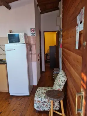 a kitchen with a refrigerator and a chair and a microwave at Cabaña Alma 2 in Villa Carlos Paz