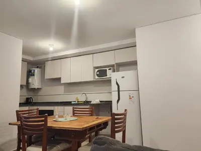 a kitchen with a wooden table and a refrigerator at DPTO Catedralle Alta Cordoba PB in Cordoba