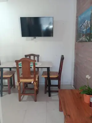 a dining room table with chairs and a television on a wall at Fenix in Alto de la Piedra