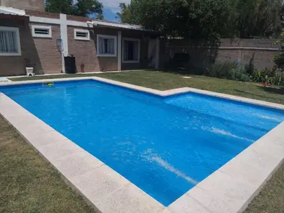 a large blue swimming pool in the yard of a house at Fenix in Alto de la Piedra