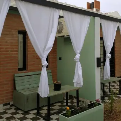 a patio with a bench and curtains at Sierras Alojamiento SUITE in Mina Clavero