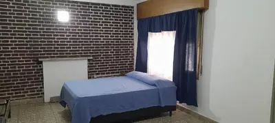 a bedroom with a bed and a brick wall at Monoambiente Anisacate in Villa Anizacate