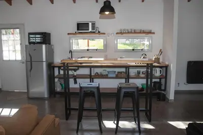 a kitchen with a counter and stools in a room at Bandruidh - Morada serrana - V. Gral. Belgrano in Villa General Belgrano