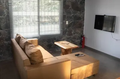 a living room with a couch and a table at Bandruidh - Morada serrana - V. Gral. Belgrano in Villa General Belgrano