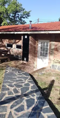 a brick house with a stone walkway in front of it at Bandruidh - Morada serrana - V. Gral. Belgrano in Villa General Belgrano
