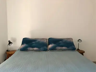 a bed with two pillows with clouds on them at ALOHA Güemes Premium, Moderno dpto 1 dorm TORRES H in Cordoba