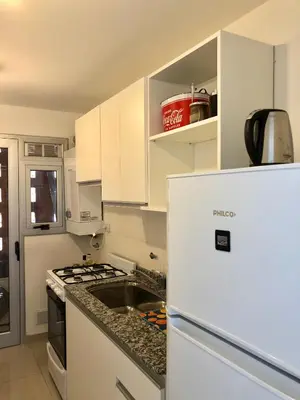a kitchen with white cabinets and a white refrigerator at ALOHA Güemes Premium, Moderno dpto 1 dorm TORRES H in Cordoba