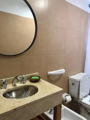 a bathroom with a sink and a mirror and a toilet at ALOHA Güemes Premium, Moderno dpto 1 dorm TORRES H in Cordoba