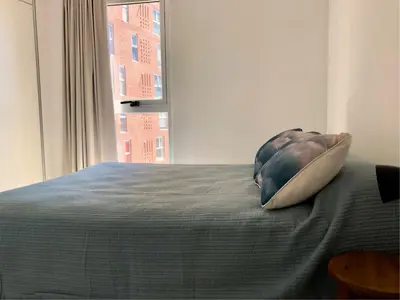 a pillow sitting on a bed with a window at ALOHA Güemes Premium, Moderno dpto 1 dorm TORRES H in Cordoba