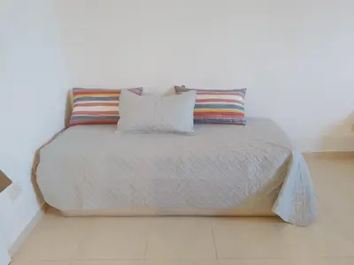a bed with two pillows on it in a room at CiTriPio dpto con Aire acondiconado , wifi y TV in Cordoba