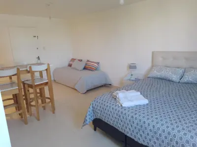 a bedroom with a bed and a table and a chair at CiTriPio dpto con Aire acondiconado , wifi y TV in Cordoba
