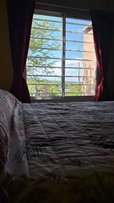 a bedroom with a bed and a large window at Sendero de Luna in Santa Rosa de Calamuchita