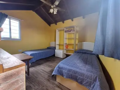 a bedroom with two beds and a ceiling fan at Sendero de Luna in Santa Rosa de Calamuchita