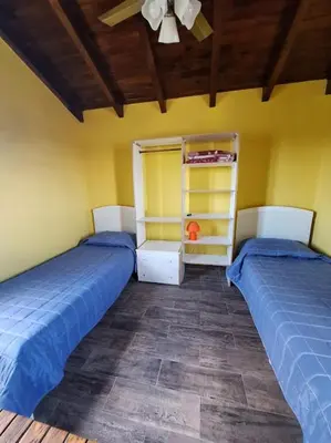 a bedroom with two beds and a ceiling at Sendero de Luna in Santa Rosa de Calamuchita