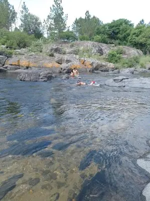 a group of people swimming in a river at Sendero de Luna in Santa Rosa de Calamuchita