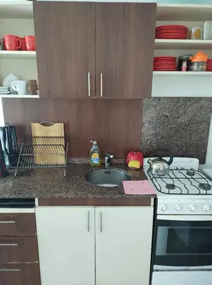 a kitchen with a sink and a stove and cabinets at Piso entero en la mejor ubicación in Cordoba