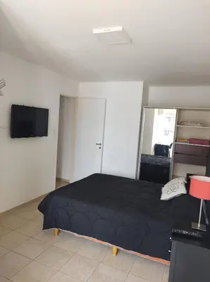 a bedroom with a black bed and a flat screen tv at Piso entero en la mejor ubicación in Cordoba