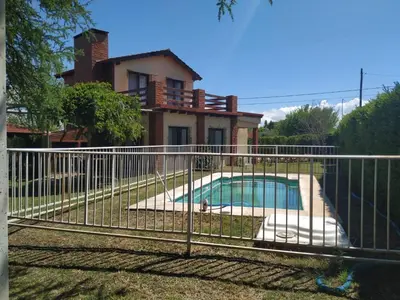 a fence around a swimming pool in front of a house at Cabaña Arroyo de los Patos in Arroyo de Los Patos