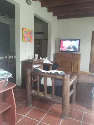a living room with a bench and a tv at Cabaña Arroyo de los Patos in Arroyo de Los Patos