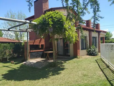 a small house with a tree in the yard at Cabaña Arroyo de los Patos in Arroyo de Los Patos