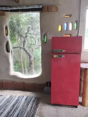 a red refrigerator in a room with a window at ECO-LOFT, Sombra de Chañar,- Mallín Córdoba in Tanti