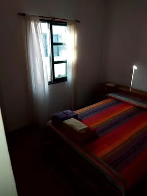 a bedroom with a striped bed with a window at Castillo Del Lago - Carlos Paz - D07 in Villa Carlos Paz