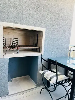 two chairs and a table in a room with a desk at DEPARTAMENTO DE 1 DORMITORIO CON VISTA A LAS SIERRAS Av Colon 5034 in Cordoba