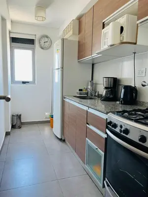 a kitchen with a stove and a refrigerator at DEPARTAMENTO DE 1 DORMITORIO CON VISTA A LAS SIERRAS Av Colon 5034 in Cordoba