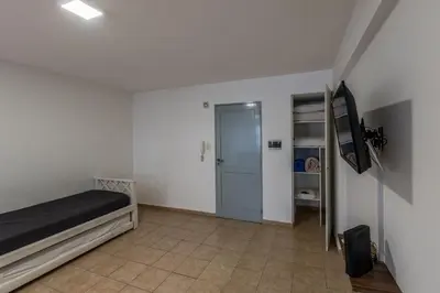 a bedroom with a bed and a tv and a door at Departamento familiar en Nueva Cordoba by lofty in Cordoba