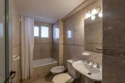 a bathroom with a toilet and a sink and a tub at Departamento familiar en Nueva Cordoba by lofty in Cordoba