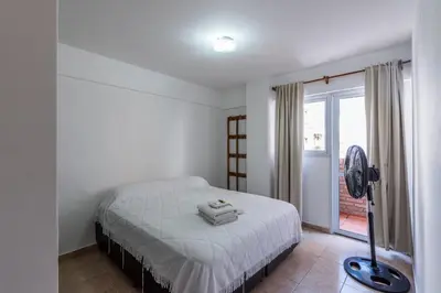 a bedroom with a bed and a fan and a window at Departamento familiar en Nueva Cordoba by lofty in Cordoba