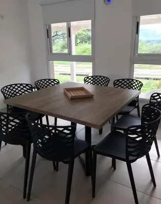 a wooden table and chairs in a room at La Pasionaria casa de sierras in Santa Rosa de Calamuchita