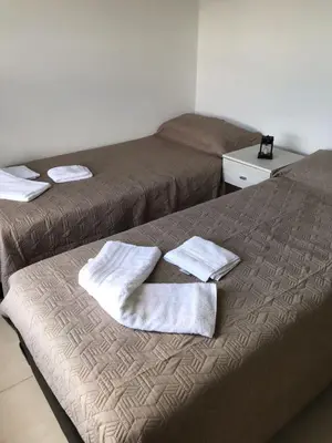 two beds in a room with towels on the bed at La Pasionaria casa de sierras in Santa Rosa de Calamuchita
