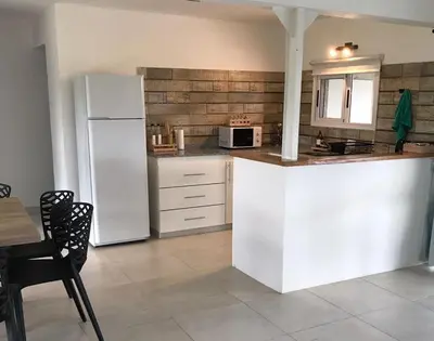 a kitchen with a white refrigerator and a table at La Pasionaria casa de sierras in Santa Rosa de Calamuchita