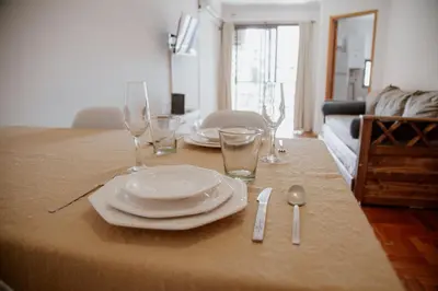 a table with plates and wine glasses on it at Departamento en Obispo Trejo by Lofty in Cordoba