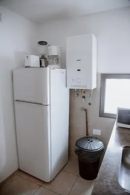 a kitchen with a white refrigerator and a trash can at Departamento en Obispo Trejo by Lofty in Cordoba