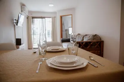 a table with plates and glasses on top of it at Departamento en Obispo Trejo by Lofty in Cordoba