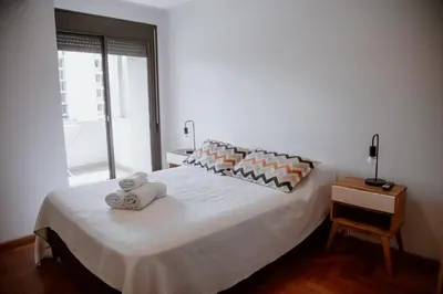 a bedroom with a white bed with towels on it at Departamento en Obispo Trejo by Lofty in Cordoba