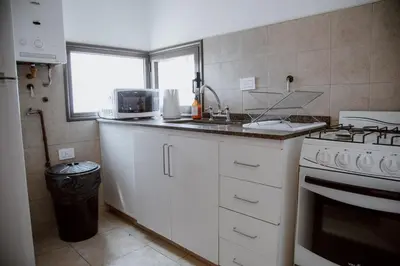 a kitchen with a sink and a stove and a window at Departamento en Obispo Trejo by Lofty in Cordoba