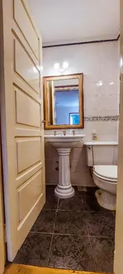 a bathroom with a sink and a toilet and a mirror at El Solar de los Pájaros in Merlo
