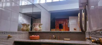 a bathroom with a large mirror and a sink at El Solar de los Pájaros in Merlo