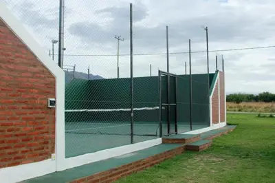 a tennis court behind a fence in a field at Winds Hill Resort & Spa in Merlo